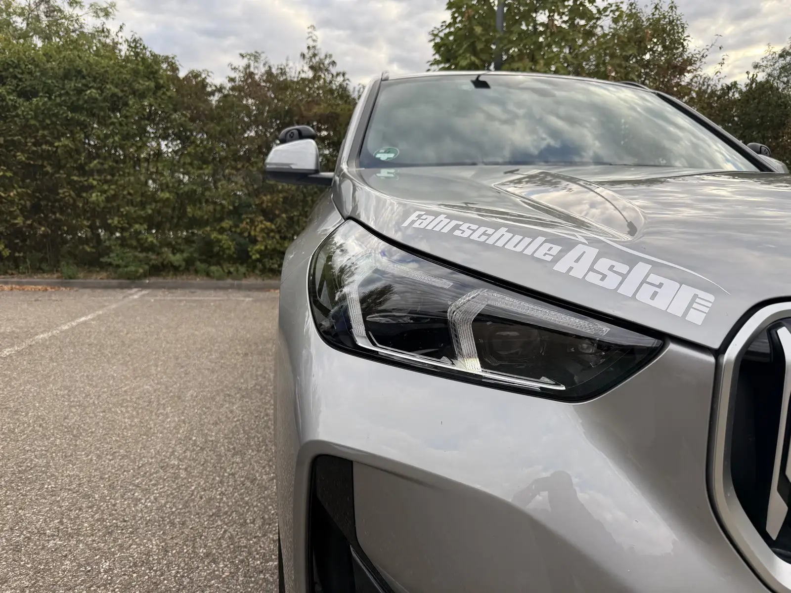 Logo der Fahrschule Aslan auf der Motorhaube eines Fahrschulautos
